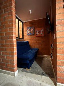 a living room with a blue couch in a brick wall at Casa Roma - La tranquilidad del campo en la Ciudad - RNT 1 0 8 1 3 7- in Salento +21 photos