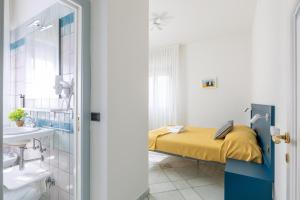 a bedroom with a bed and a sink in a room at Affittacamere Prima Fila Mare in Porto Recanati
