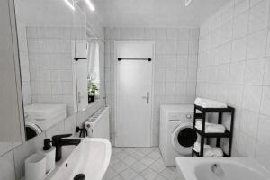 a bathroom with a sink and a washing machine at The Günz Homes 1 in Günzburg