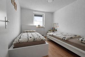 a bedroom with two beds and a window at The Günz Homes 1 in Günzburg