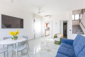 a living room with a blue couch and a table at Affittacamere Prima Fila Mare in Porto Recanati