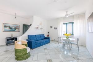 a living room with a blue couch and a table at Affittacamere Prima Fila Mare in Porto Recanati