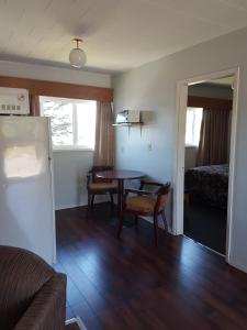a living room with a table and a bed at Alberni Inn in Port Alberni