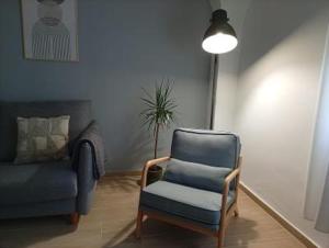 a living room with a chair and a couch at Apartamentos La Machacona Plaza Mayor recién reformados in Cáceres
