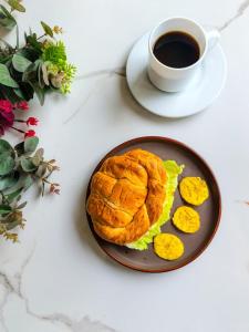 a plate with a sandwich and a cup of coffee at Hotel Lince in Lima