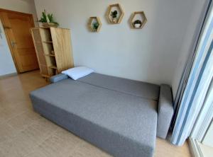 a bed sitting in a room next to a window at Charli beach in Miramar