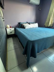 a bedroom with a bed with a blue comforter at 4 min do Paraguai Casa com piscina e privacidade in Foz do Iguaçu