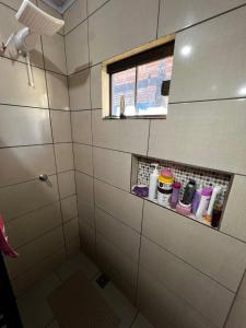 a bathroom with a shower stall with a window at 4 min do Paraguai Casa com piscina e privacidade in Foz do Iguaçu +10 photos