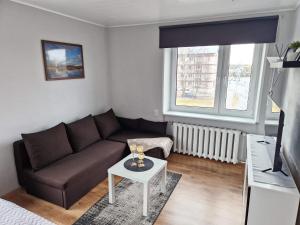 a living room with a couch and a table at Central Haapsalu Apartment in Haapsalu