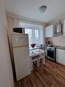 a kitchen with a white refrigerator and a table with flowers at Central Haapsalu Apartment in Haapsalu +4 photos