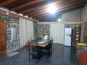 a dining room with a table and a refrigerator at Casa El molinito in Chilecito