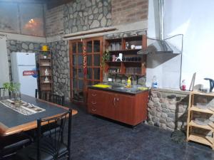 a kitchen with a sink and a counter with a table at Casa El molinito in Chilecito