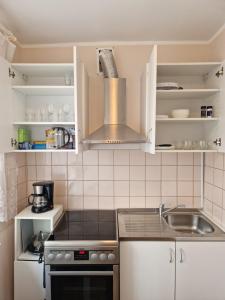 a kitchen with a sink and a stove top oven at Central Haapsalu Apartment in Haapsalu