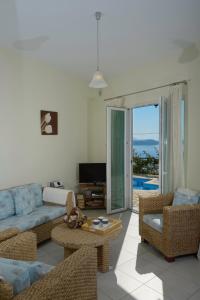 a living room with a couch and chairs and a television at Eleonora Villa in Évyiros