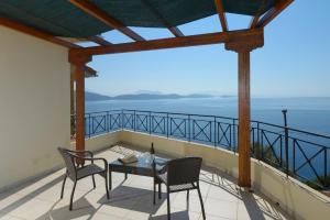 a balcony with a table and chairs and the ocean at Eleonora Villa in Évyiros +1 photo