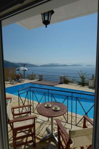 a balcony with a table and chairs and a pool at Eleonora Villa in Évyiros