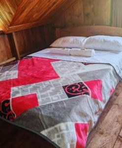a bed with a quilt on it in a room at Las Bromelias in Coconuco