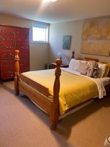 a bedroom with a large bed with a yellow bedspread at Sunset Ocean Retreat in West Vancouver