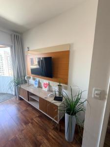 a room with a desk with a television on a wall at Flat Completo Suíte com Terraço, Cozinha, Garagem Manobrista Liberdade, Paraíso 24h in São Paulo +21 photos