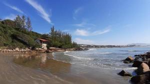 a house on the shore of a rocky beach at Riba House in Imbituba