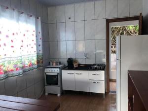 a small kitchen with a stove and a window at Riba House in Imbituba