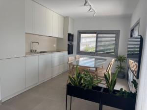 a kitchen with white cabinets and a table and chairs at Terraza Montaña in Nerja