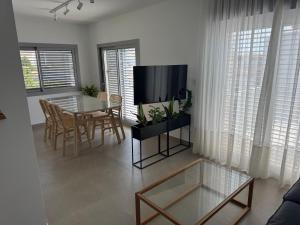 a living room with a tv and a table and chairs at Terraza Montaña in Nerja