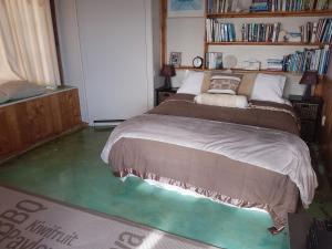 a bedroom with a bed and a green floor at Raglan Vista in Raglan +4 photos