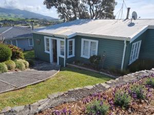 a small blue house with a yard at Raglan Vista in Raglan