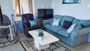 a living room with a blue couch and a table at Raglan Vista in Raglan