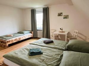 a bedroom with two beds and a table and a window at Hof Gottesbüren in Warburg