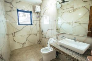 a bathroom with a sink and a toilet and a mirror at Kubn Retreat in Chandigarh Airport