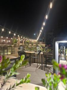 a patio with tables and chairs and lights at night at B Suites Boutique Hotel in Amman