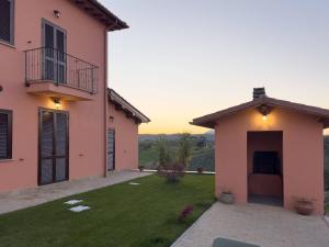 a house with a green yard next to a building at Casale Saporito in Montopoli in Sabina