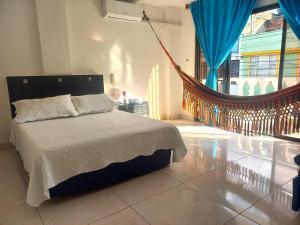 a bedroom with a bed and a hammock in it at Hotel Los Balcones de Apulo in Apulo +26 photos