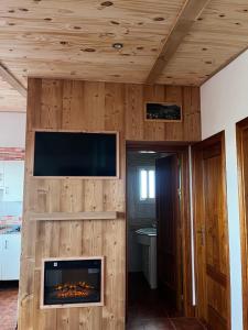 a living room with a fireplace and a flat screen tv at Chalet Suizo in Arcos de la Frontera