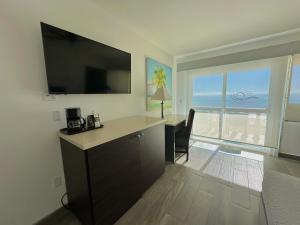 a room with a desk and a large window with the ocean at Hotel Playa Bonita Resort in Puerto Peñasco
