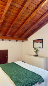 a bedroom with a large bed with a wooden ceiling at Santo Cristo Loft in Lajes das Flores