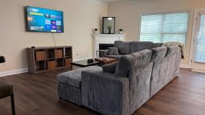 a living room with a couch and a tv at Charming townhouse ideally situated in Grayson in Grayson