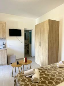 a bedroom with a bed and a table and a kitchen at Villa Adi Saranda in Sarandë