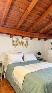 a bedroom with a large bed with wooden ceilings at Santo Cristo Loft in Lajes das Flores +14 photos