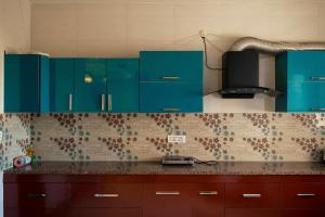 a kitchen with blue cabinets and a counter top at 2Kubn retreat in Chandigarh Airport