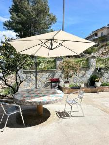 a table with an umbrella and two chairs at Villa Adi Saranda in Sarandë