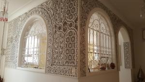 an ornate wall with two windows in a room at Chez Eric in Akhfennirr