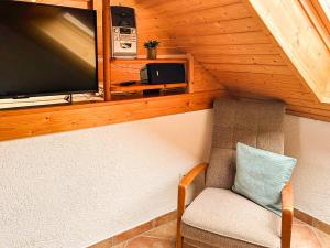 a living room with a tv and a chair at Hof Gottesbüren in Warburg