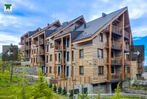 a large wooden apartment building with a metal roof at Maksim 2 in Iglići