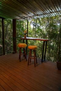a table and two stools sitting on a deck at Tree House in Vítor Hugo