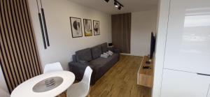 a living room with a couch and a table at Apartament 7 Piętro in Wałbrzych