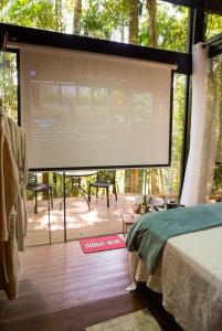 a large projection screen in a room with a bed at Tree House in Vítor Hugo