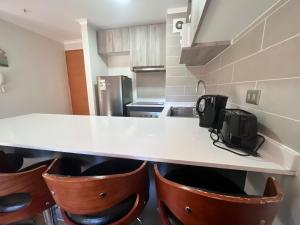 a kitchen with a counter and some brown bar stools at laguna verde apart in Los Ángeles +1 photo